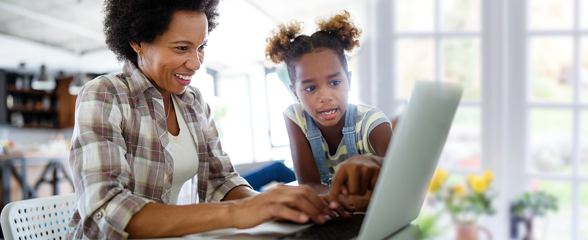 Image of a mother and her daughter looking at a laptop screen.