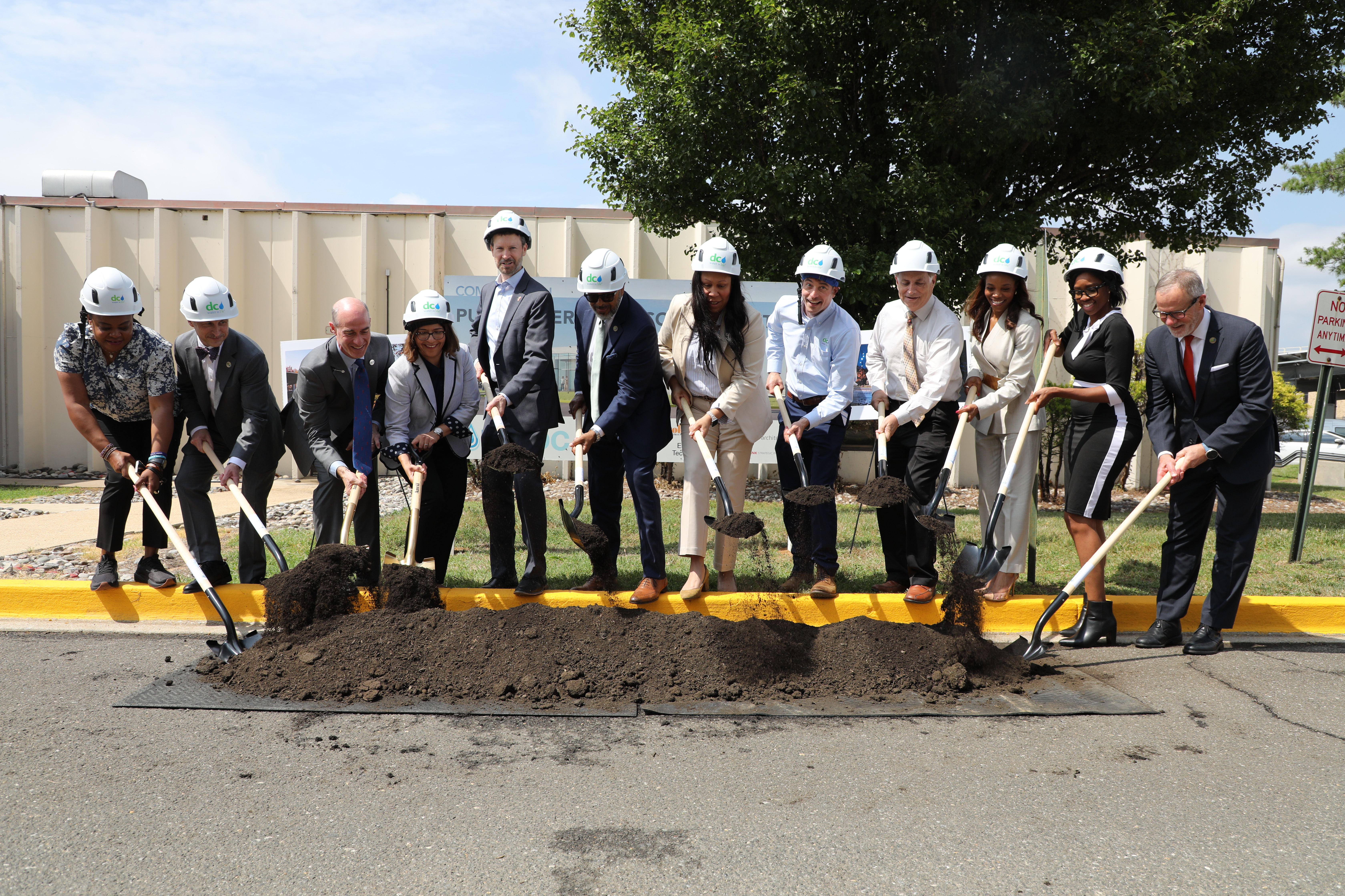 Photo of CEO, Chair, Board Members, and DC Water Staff with shovels in the pile of dirt ceremonially breaking ground