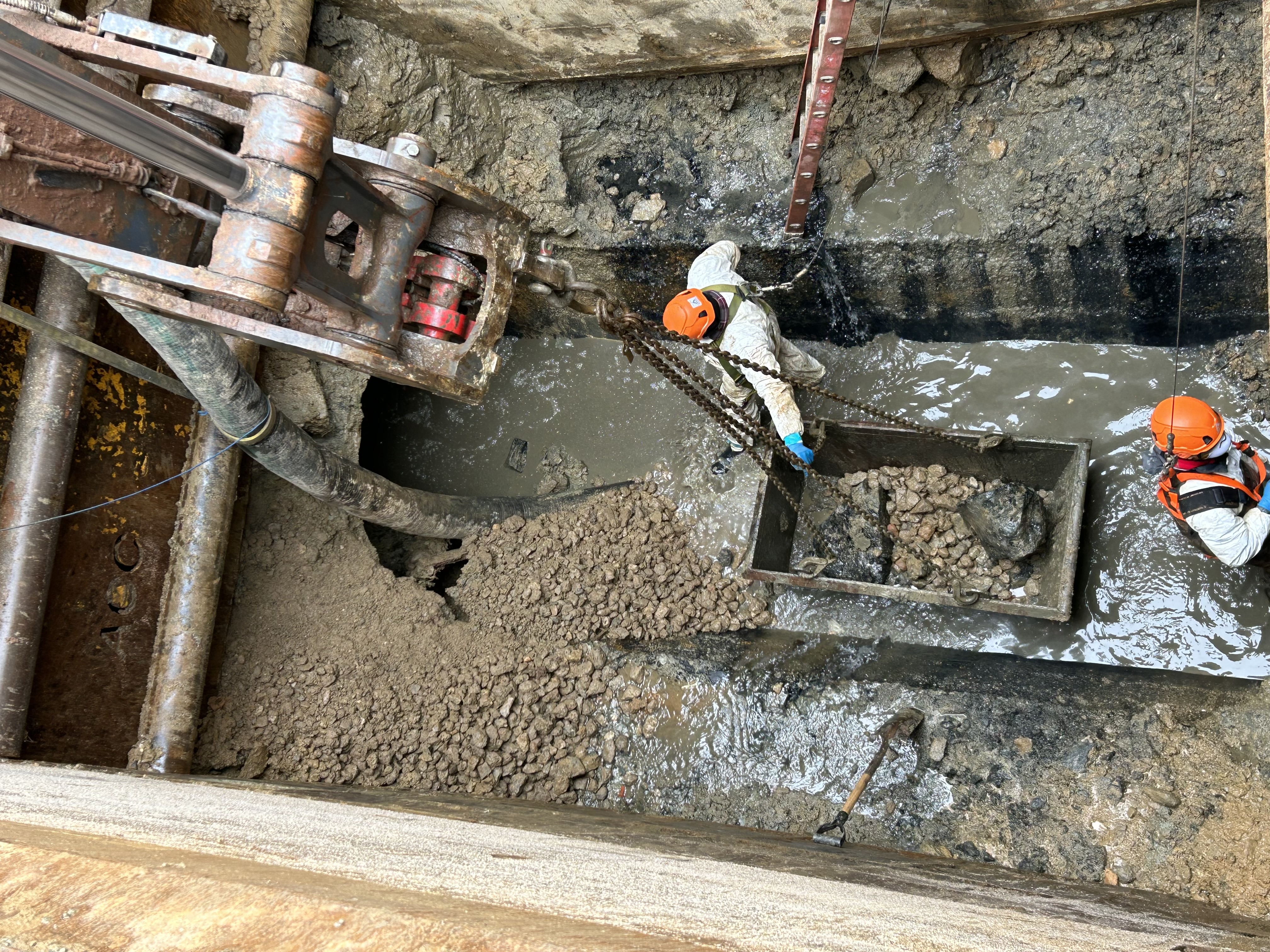 Workers clearing debris from inside the damaged pipe