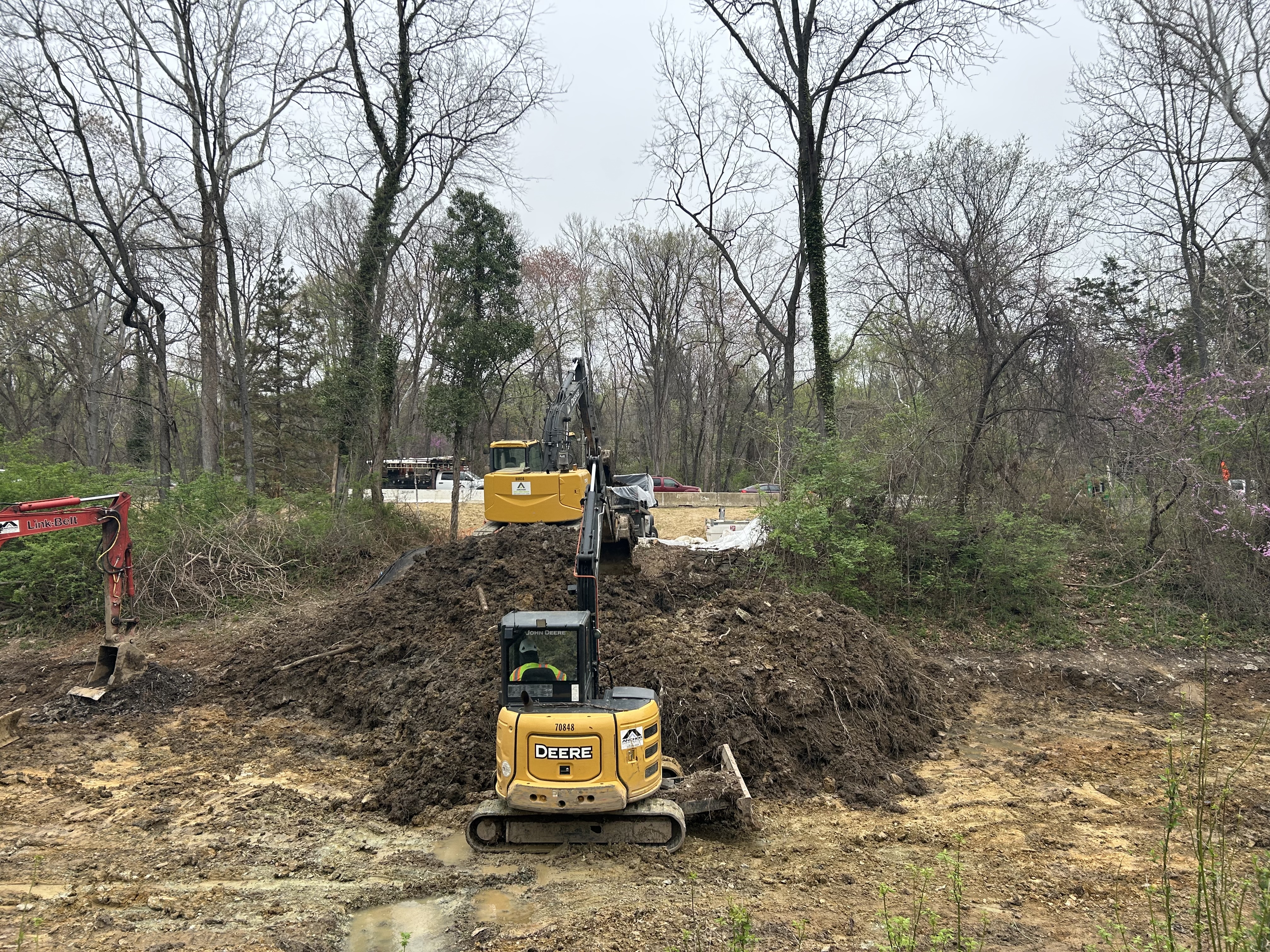Excavators in the C & O Canal removing soil and the clay liner exposed