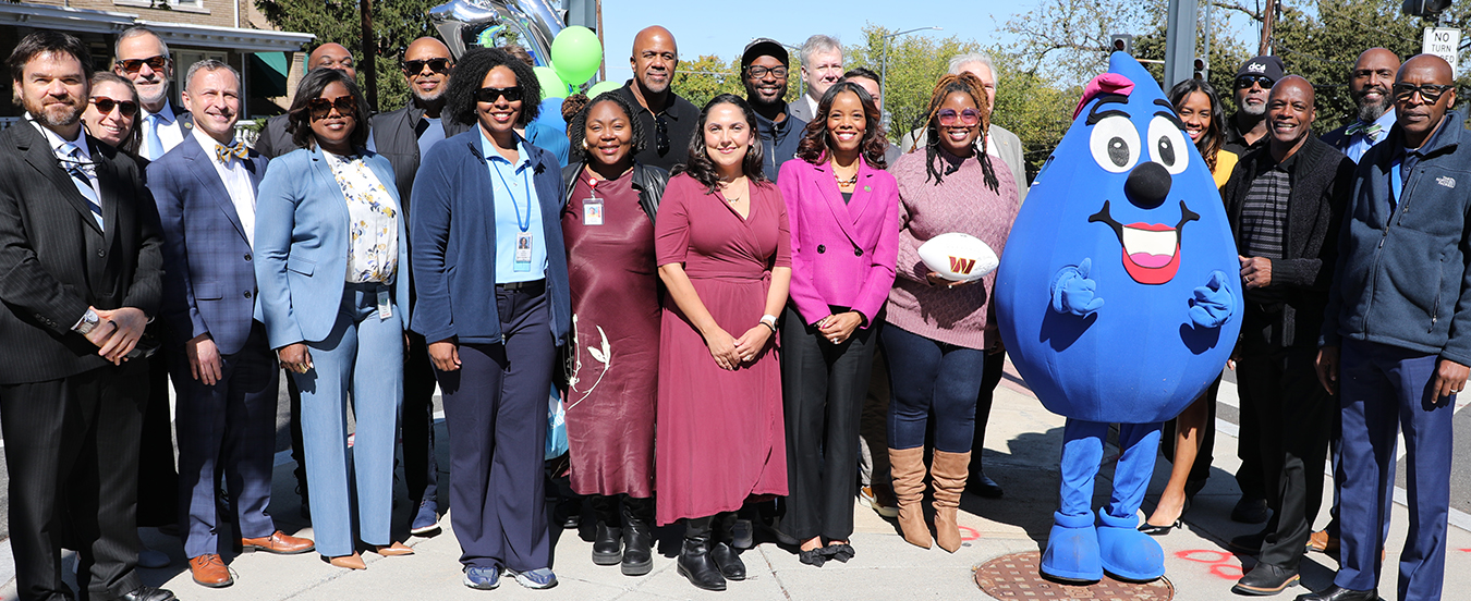 Washington football legend Darrell Green, DC Water staff and members of the community pose for a photo after an event celebrating the 10,000 lead service line replacement.