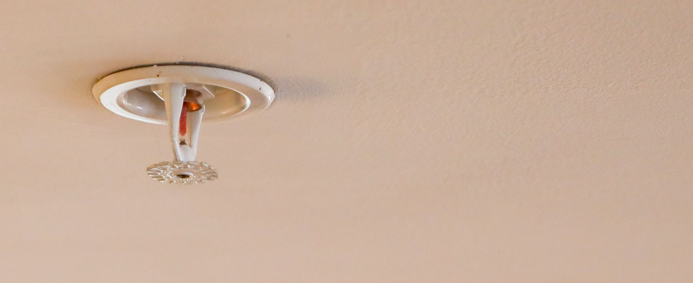 A fire sprinkler head on the ceiling of a home