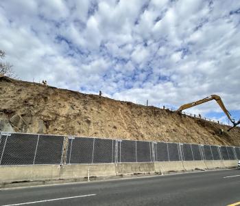 Image: A long arm machine drilling anchor bolts into the slope.