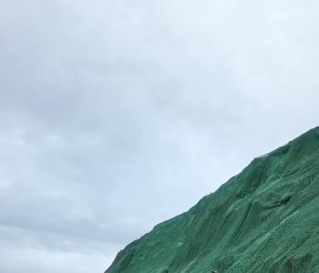 Photo of a worker on the slope an the slope with hydroseeding completed