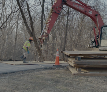 Construction crews working with crane to prepare site for bypass