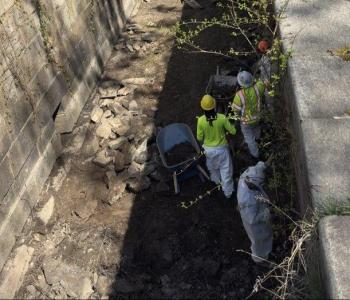 Workers manually removing soil between the locks
