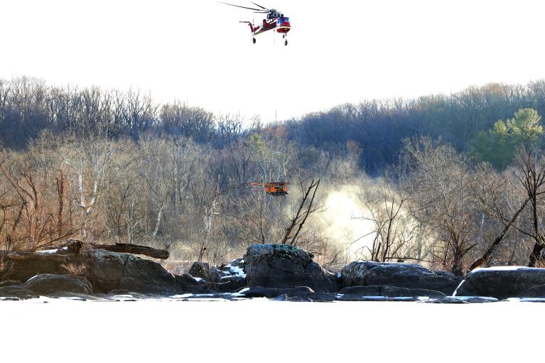 Helicopter carries equipment to drilling site Helicopter carrying drill rig equipment to boring locations in the Potomac River