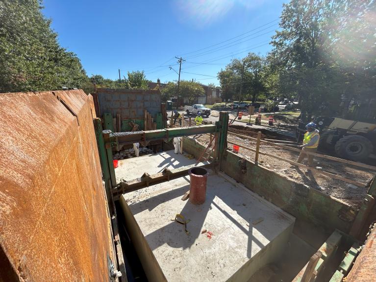 Photo of completed repair with concrete encasing the sewr pipe
