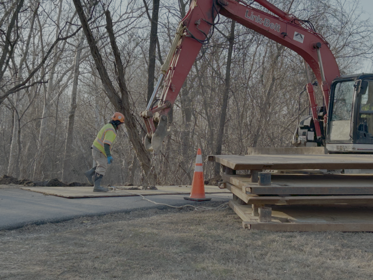 Construction crews working with crane to prepare site for bypass