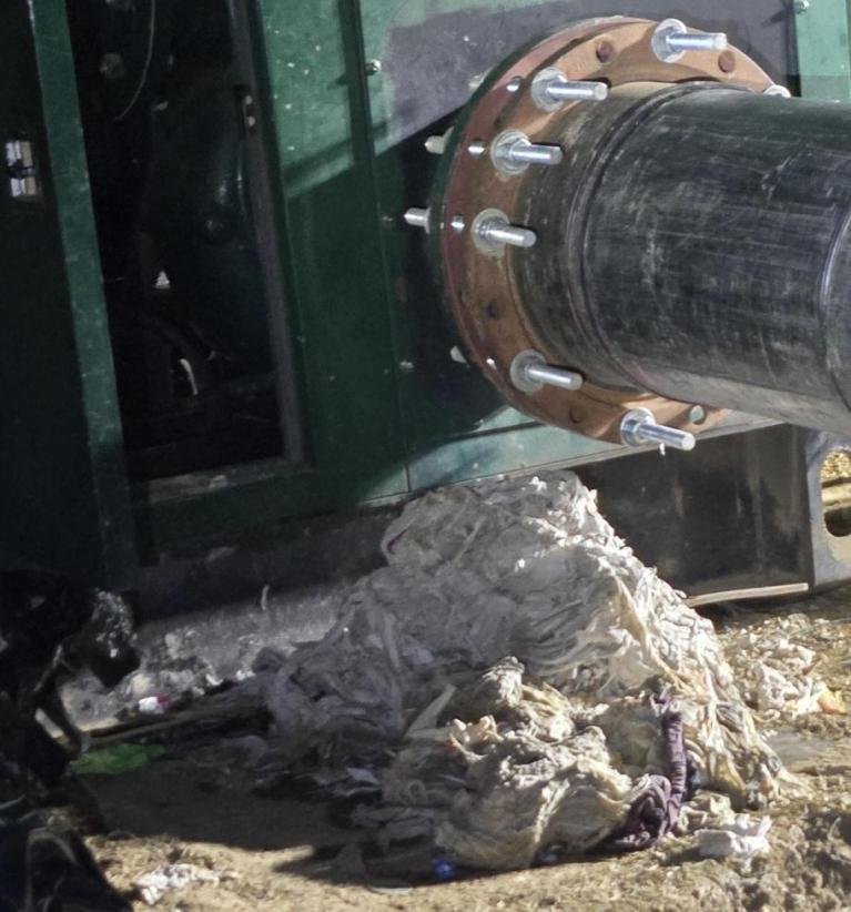 Image of pump with a large pile of wipes next to it that clogged the pump and had to be removed