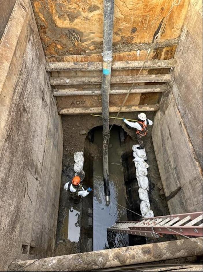 workers inside pipe cleaned of rocks and debris