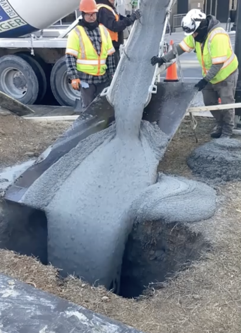 Photo of concrete being poured through a manhole or access point