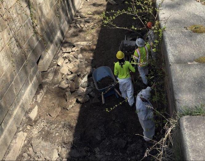 Workers manually removing soil between the locks