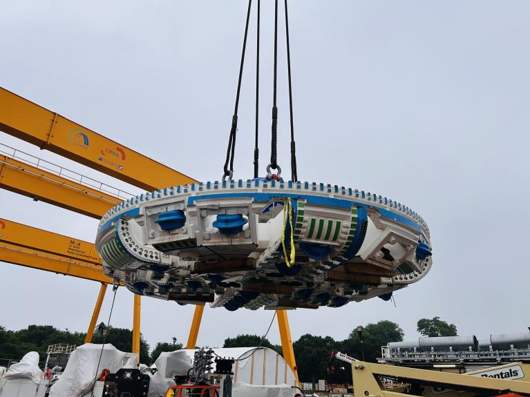 Close-up of the TBM cutterhead suspended by a crane
