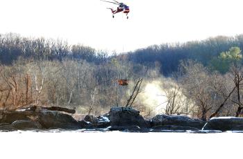 Helicopter carries equipment to drilling site Helicopter carrying drill rig equipment to boring locations in the Potomac River
