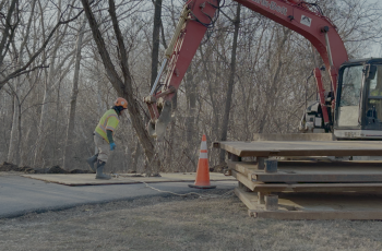 Construction crews working with crane to prepare site for bypass