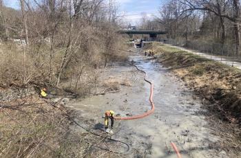 photos of workers with hoses vacuuming out canal
