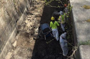 Workers manually removing soil between the locks